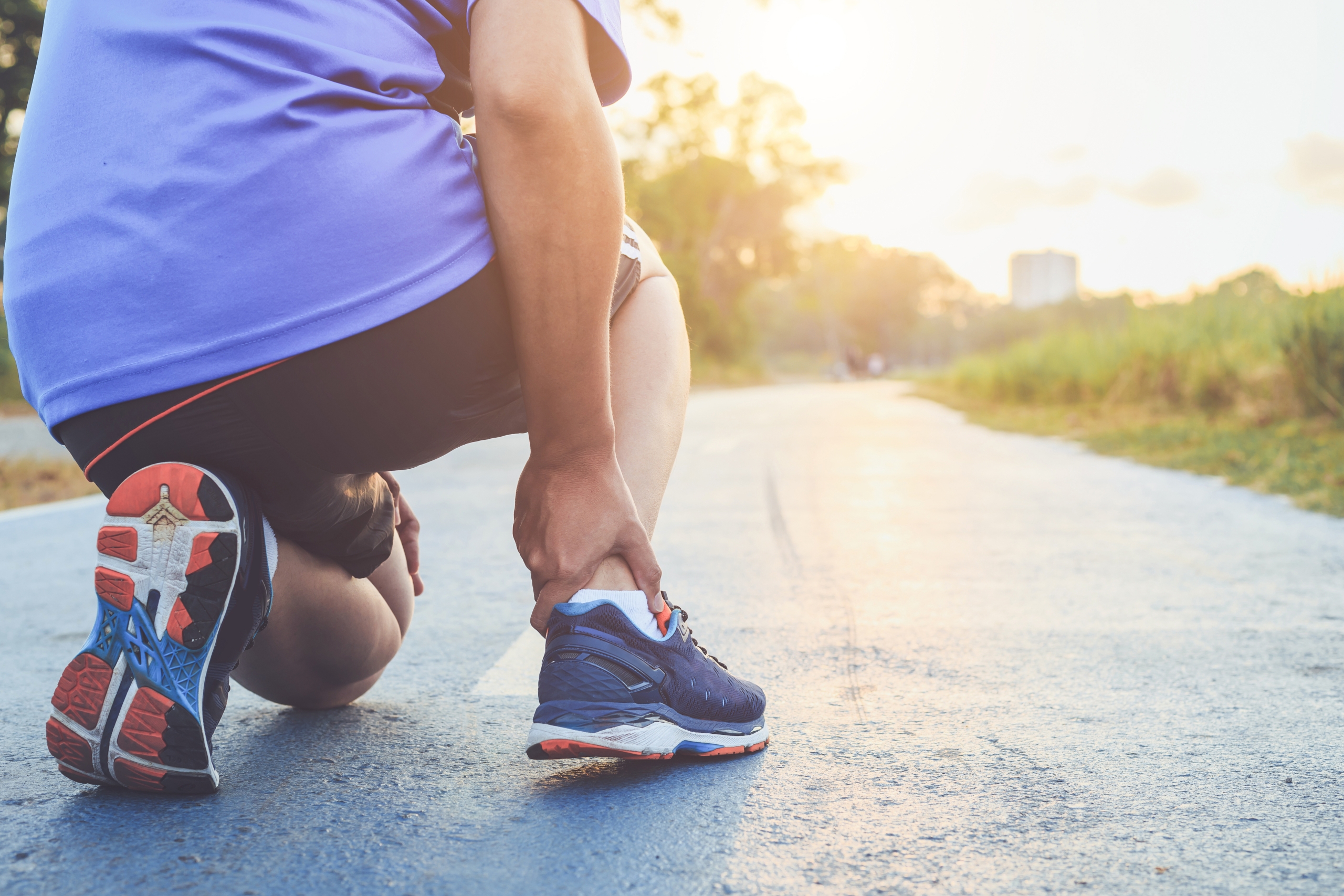 Man experiencing foot pain while running.